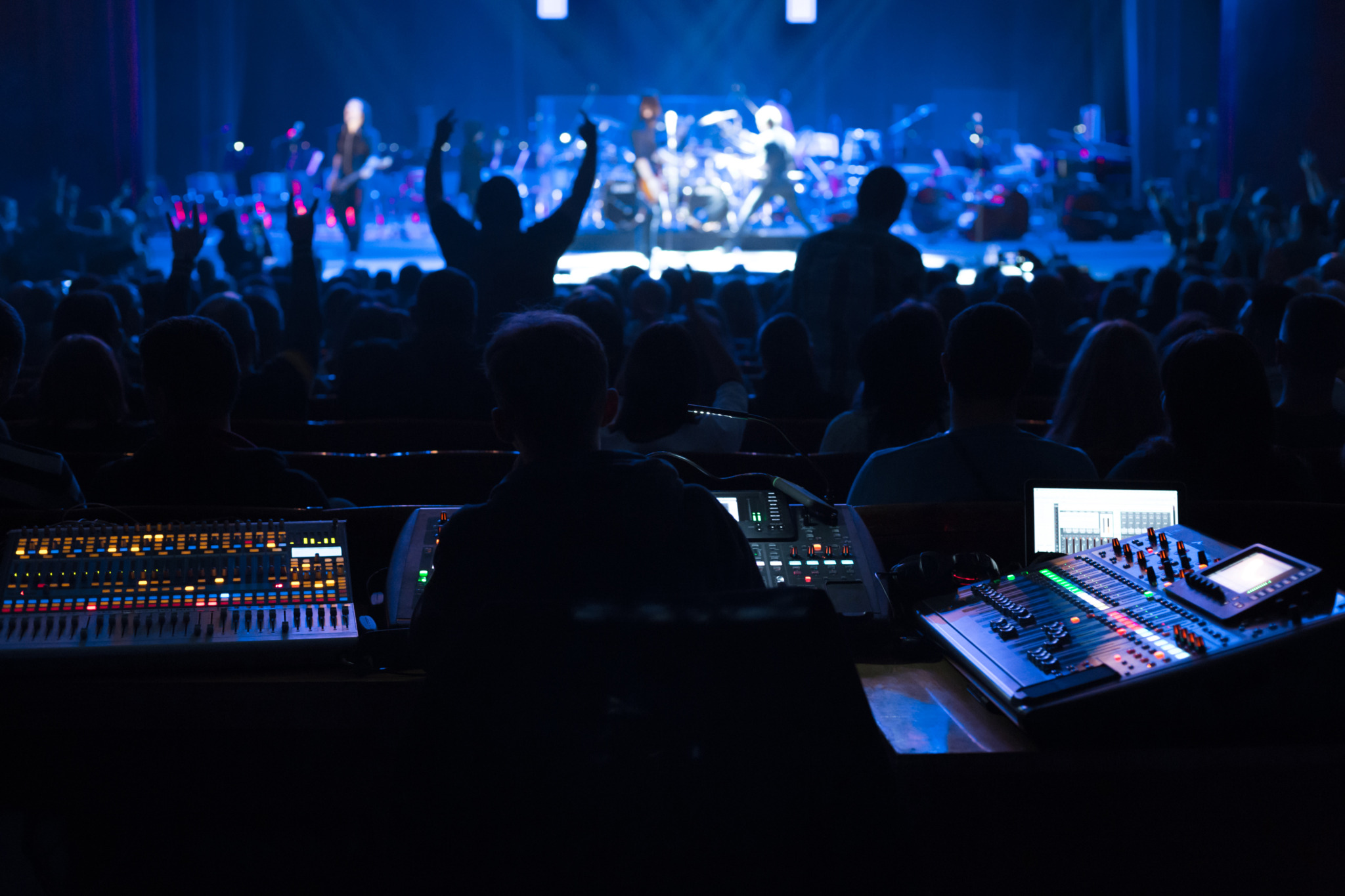 Soundman working on the mixing console in concert hall.